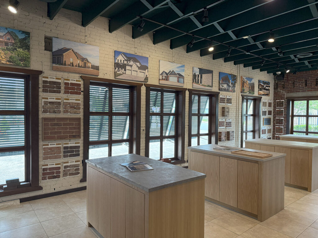 Antique Brick & Block showroom interior with brick sample panels, framed home photos, and wood display islands
