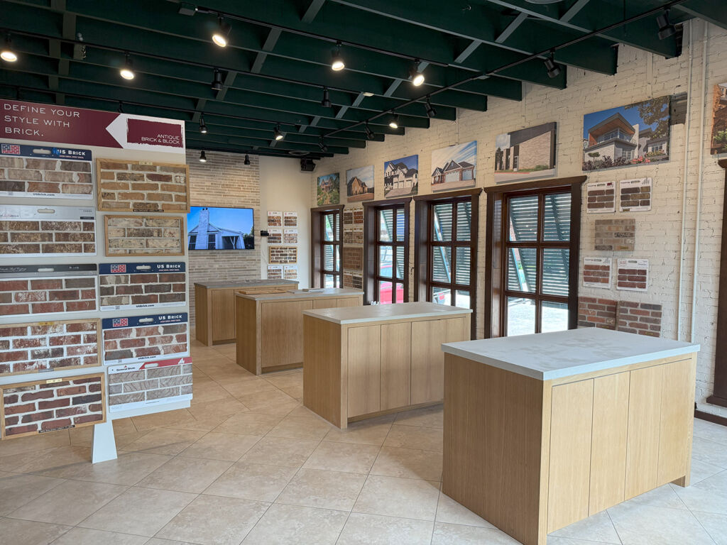 Antique Brick & Block showroom with brick sample boards, project photos on whitewashed walls, and wood display islands