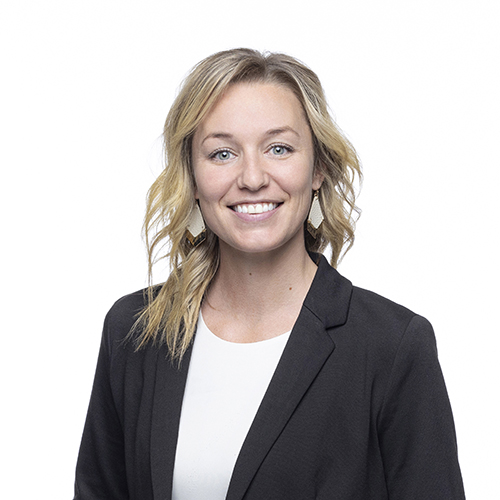 Portrait of Brook Redmon, Antique Brick & Block team member, smiling in a dark blazer