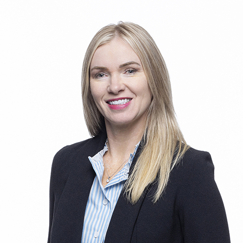 Portrait of Heather Smith, Antique Brick & Block team member, smiling in a dark blazer