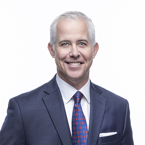 Portrait of Jason Garner, Antique Brick & Block team member, in a navy suit with patterned tie