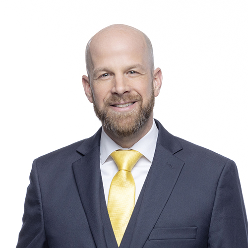 Portrait of Jeff Chastain, Antique Brick & Block team member, in a gray suit with yellow tie
