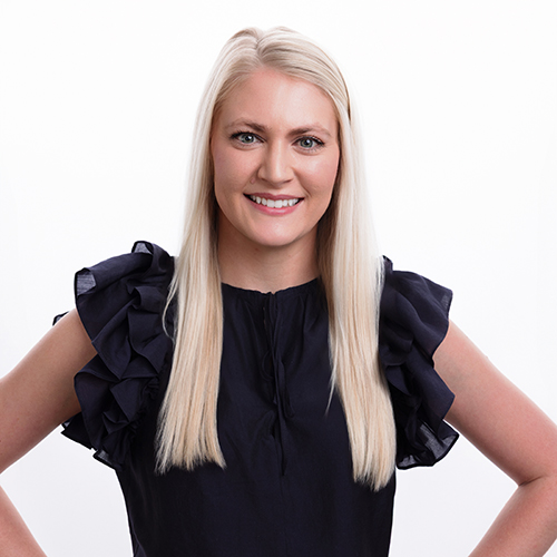 Portrait of Maddie Thomasson-Luker, Antique Brick & Block team member, in a navy ruffle top