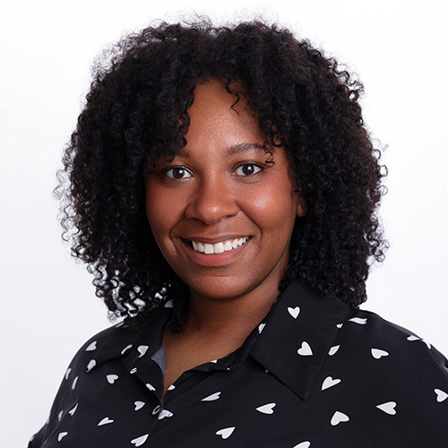Portrait of Maya Waller, Antique Brick & Block team member, in a heart-print blouse