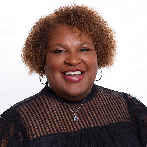 Portrait of Tamica Gulley, Antique Brick & Block team member, smiling in a black lace top